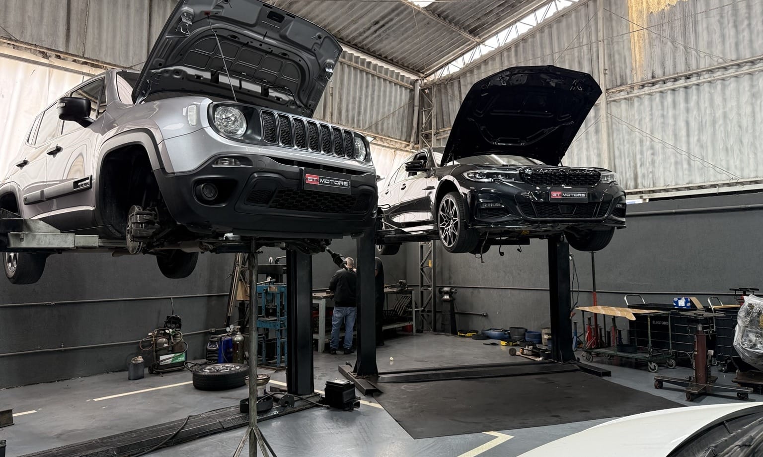Jeep Renegade e BMW em elevadores na oficina GT Motors